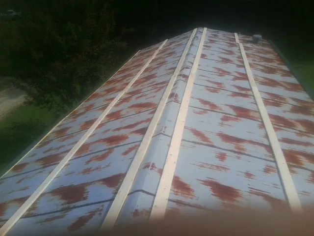 Rusted metal roof panels with new wood purlins before replacement — Storm Damage Roof Repair in Spring Lake by Roofing Brothers